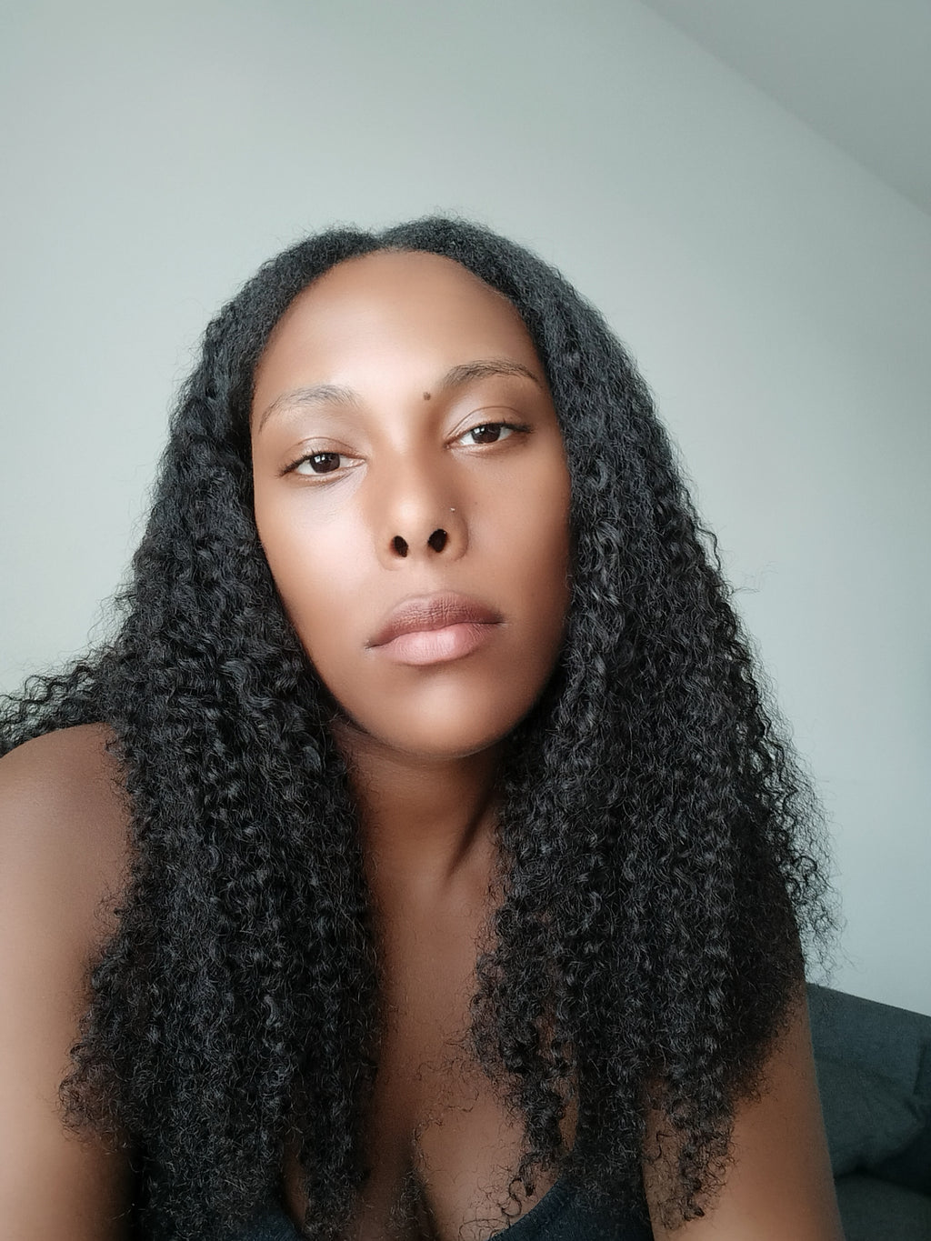 Full volume kinky curly textured hair extensions showing density and natural curl pattern indoors