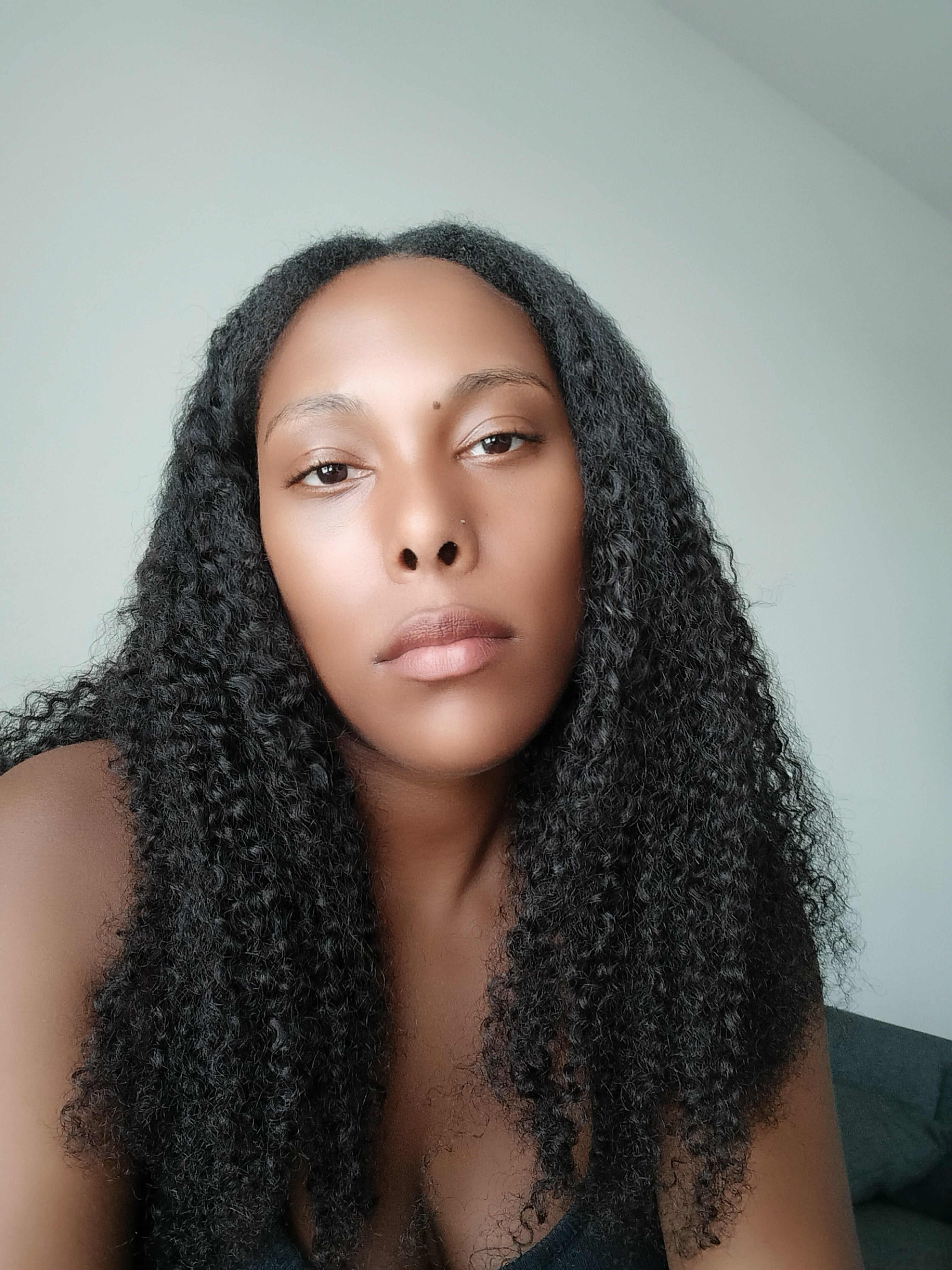 Full volume kinky curly textured hair extensions showing density and natural curl pattern indoors